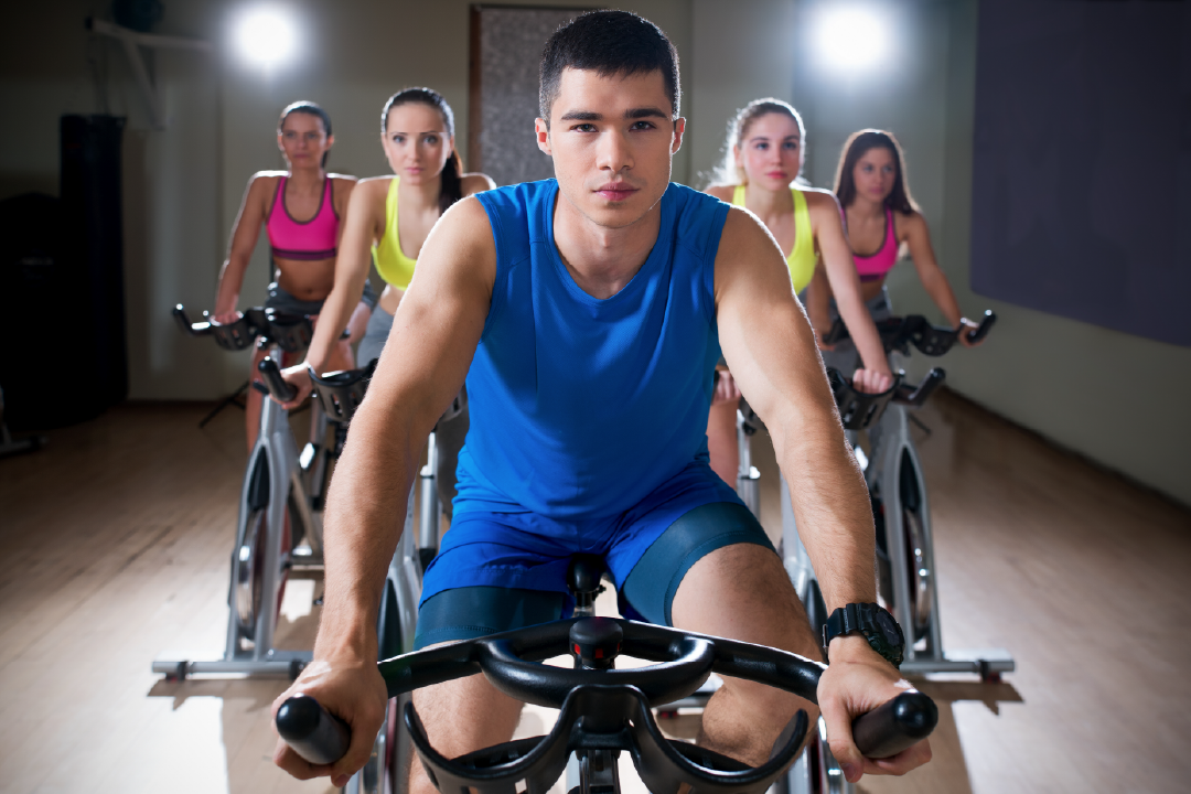 Five people on stationary bikes; personal training internship