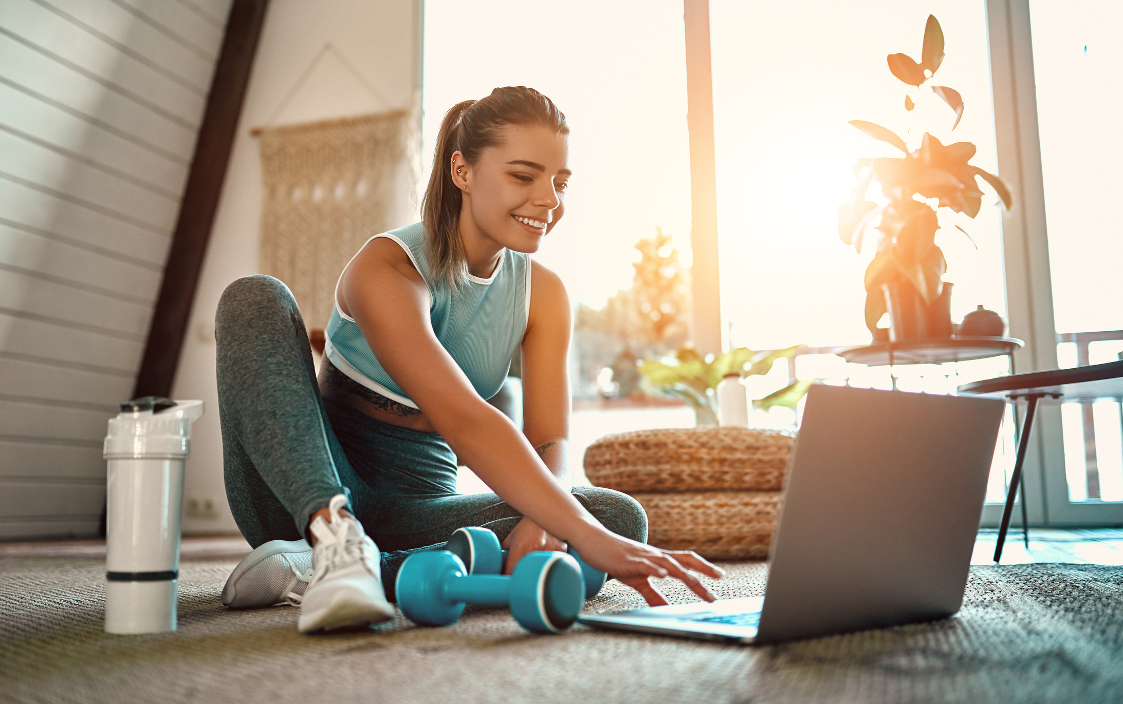 Woman in workout clothes using a computer; the online fitness business model