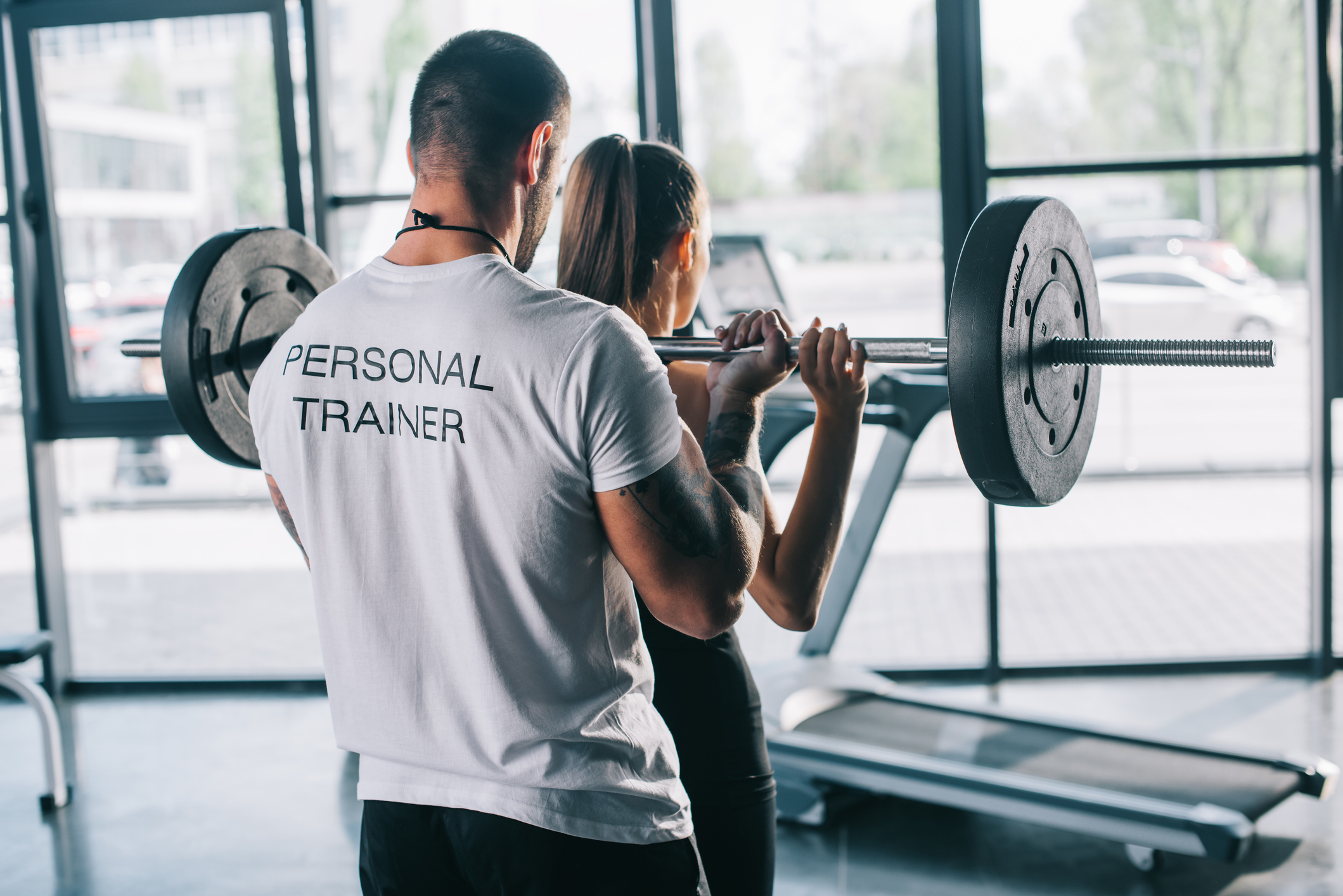 Personal trainer helping a client; starting a fitness business
